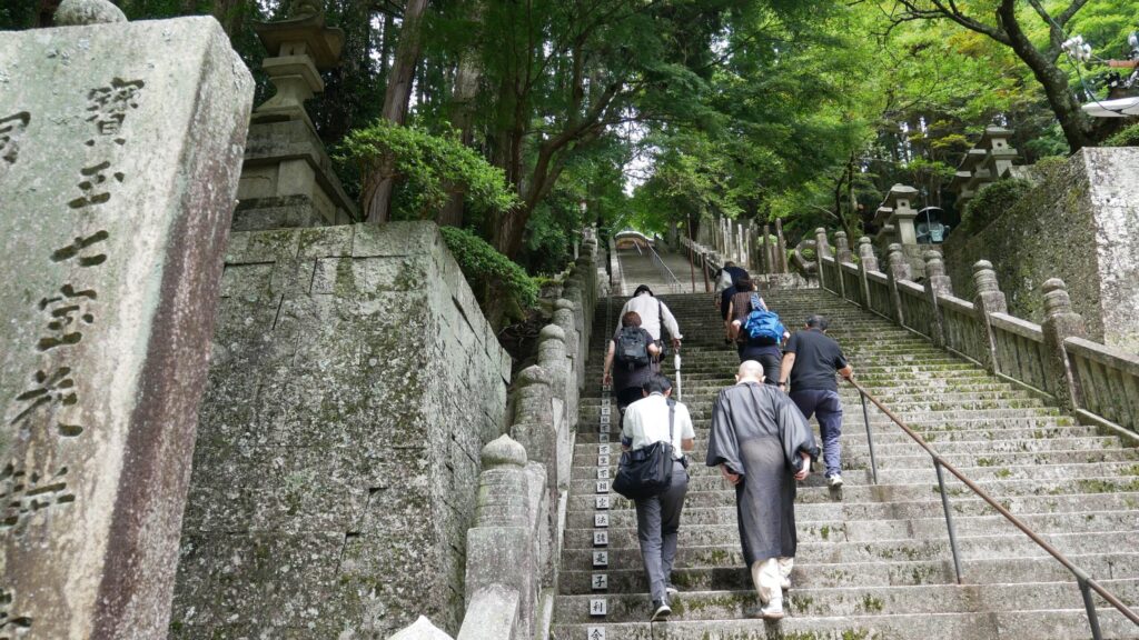 Visitors accompanied by a priest ascend the stairs of Hashikura-ji, a Bekkaku temple in Tokushima prefecture.