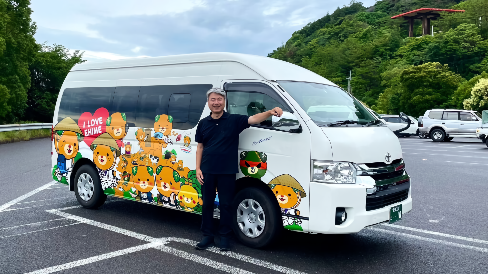 A man with an "I LOVE EHIME" Mican van.