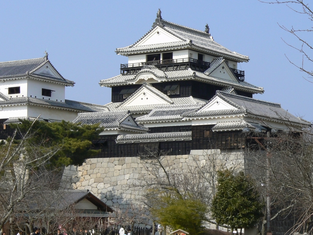 The main keep of Matsuyama Castle against a blue sky.