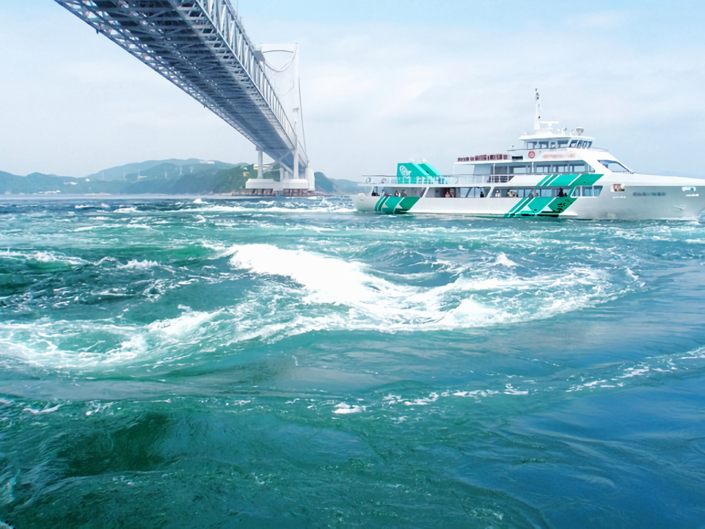 A sightseeing cruise boat navigating through the Naruto whirlpools beneath the Great Naruto Bridge in Tokushima, Japan.