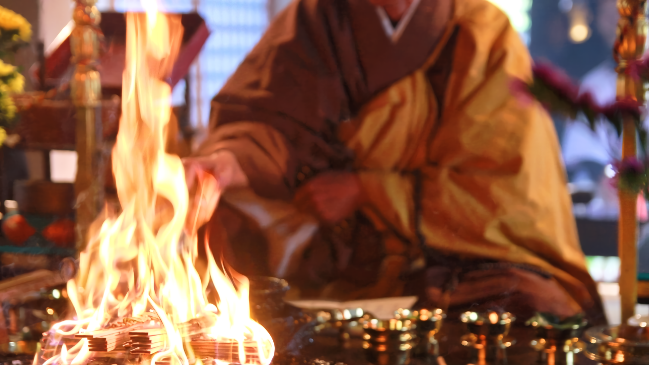 A priest feeds wooden prayer tablets (gomagi) into the ritual fire. Each tablet carries the prayers and wishes of devotees, which are believed to be carried to the Buddha through the flames.
