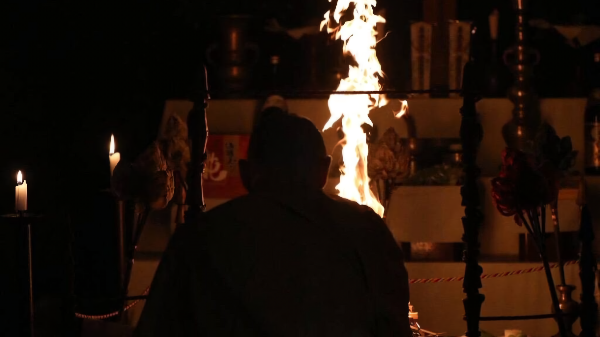 An intimate, atmospheric photograph capturing a traditional Japanese Buddhist Goma fire ritual.