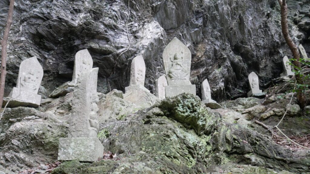 Stone Buddhas line the steep path to Konji Falls