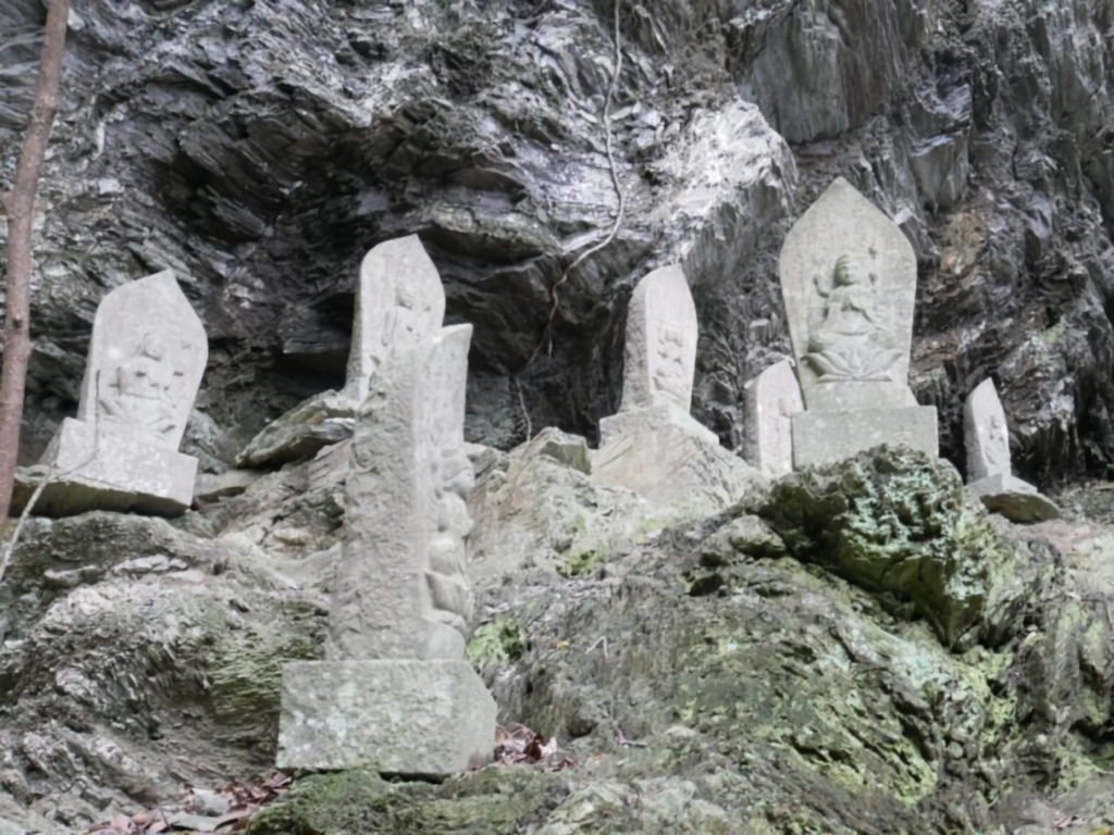 Stone Buddhas line the steep path to Konji Falls