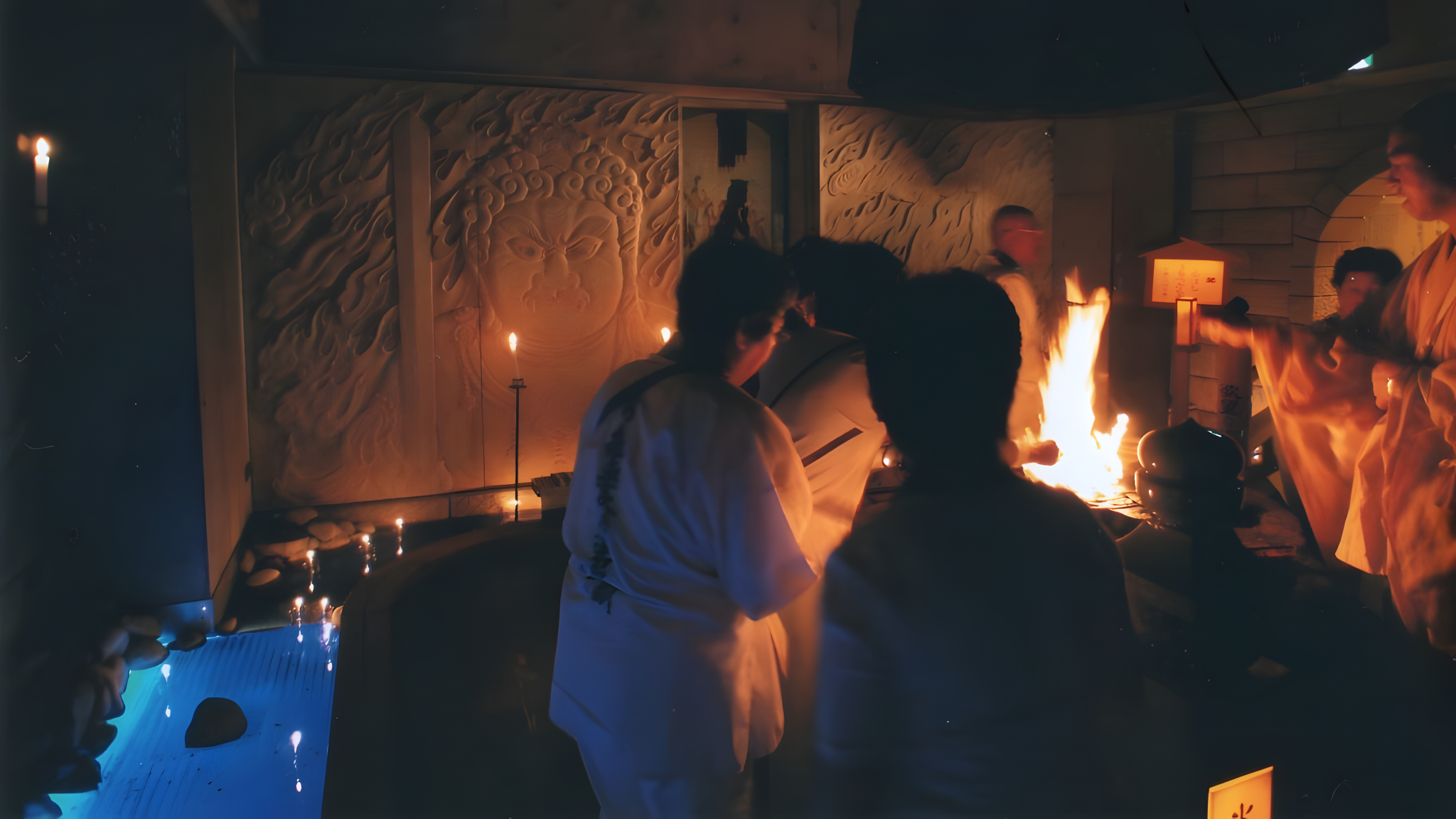 A detailed interior view of a dimly lit Japanese Buddhist temple during a traditional Goma fire ritual.