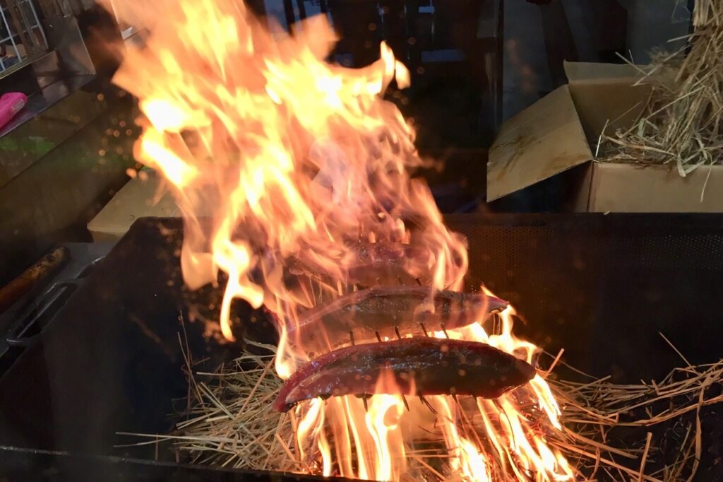 Traditional straw-searing of bonito fillets for Katsuo no Tataki, a famous local dish from Kochi.