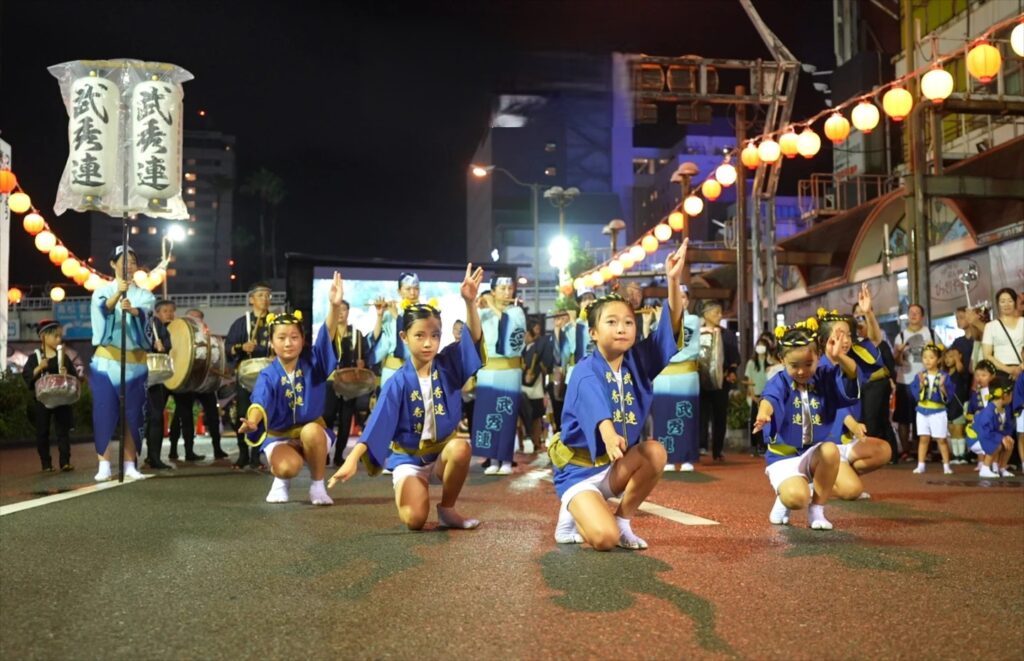 Children dancers of the Bushuren group posing on the street under lanterns at the Tokushima Awa Odori festival