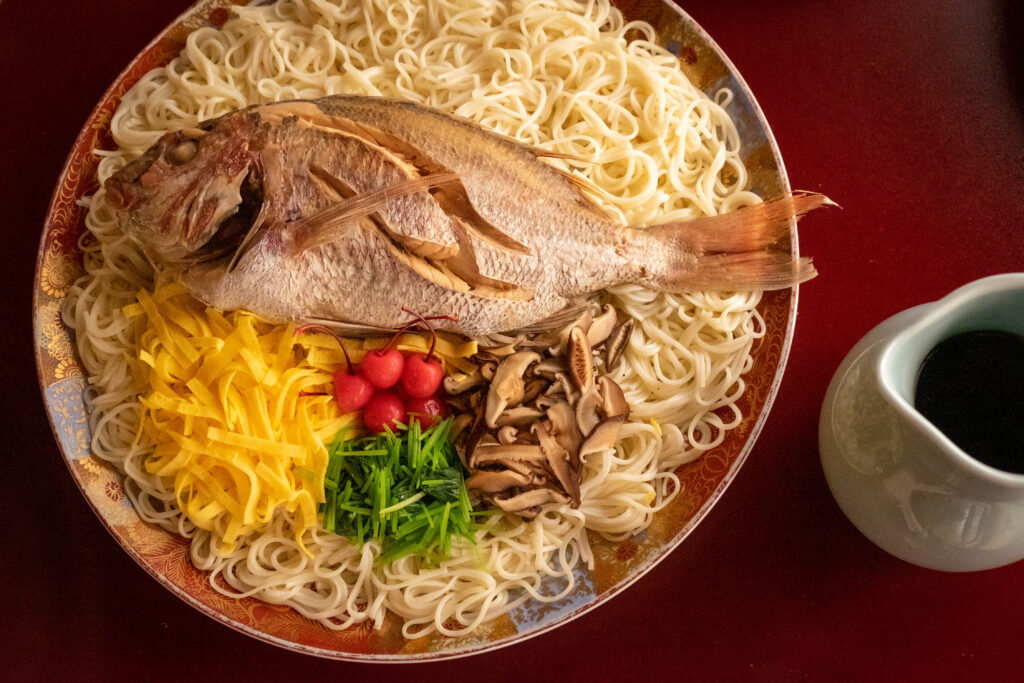 A festive platter of Tai Somen, a traditional Ehime regional dish of simmered sea bream served over somen noodles with colorful toppings.
