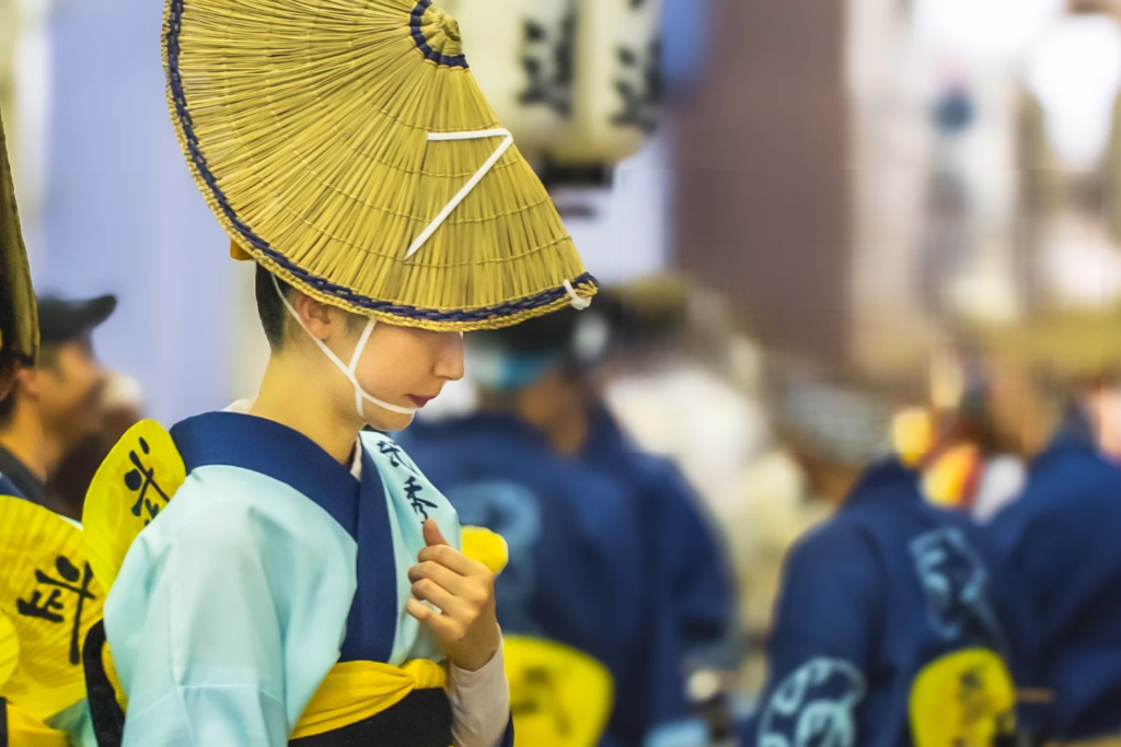 Close-up profile of a female Awa Odori dancer wearing a traditional braided straw hat (Amigasa)