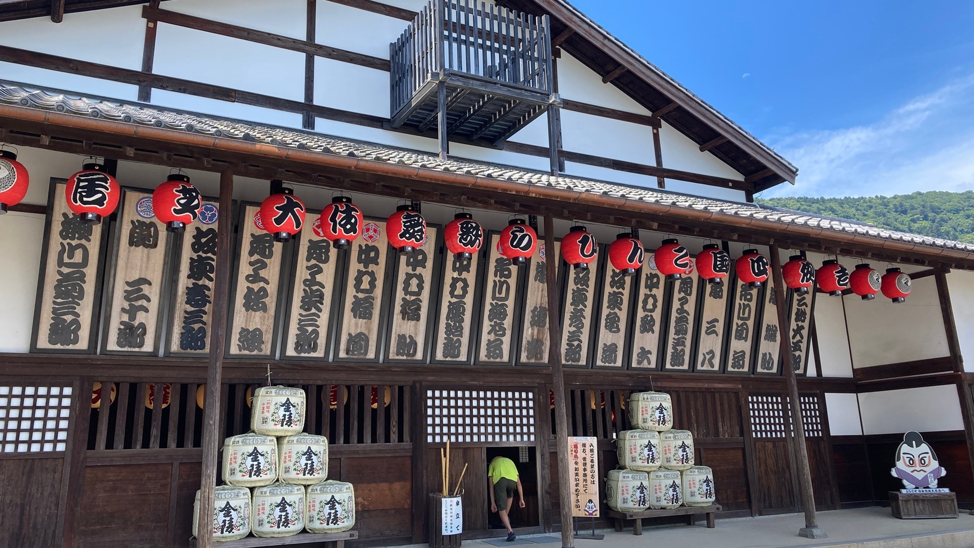 Exterior of the historic Kanamaruza kabuki theater building in Kotohira, Kagawa, with rows of red lanterns and actor name boards