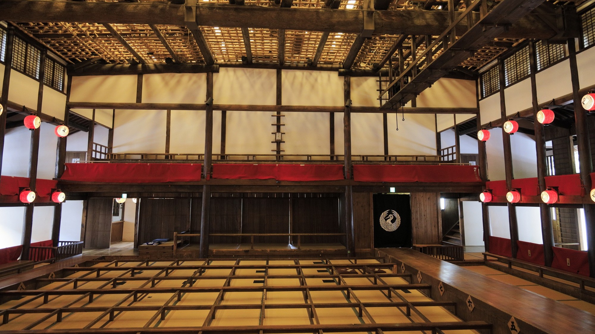 Wooden interior of Kanamaruza, Japan's oldest kabuki theater, showing the tatami audience seating and upper-floor balcony boxes