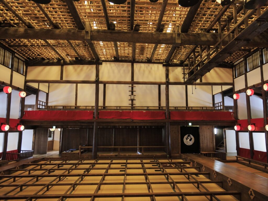Wooden interior of Kanamaruza, Japan's oldest kabuki theater, showing the tatami audience seating and upper-floor balcony boxes