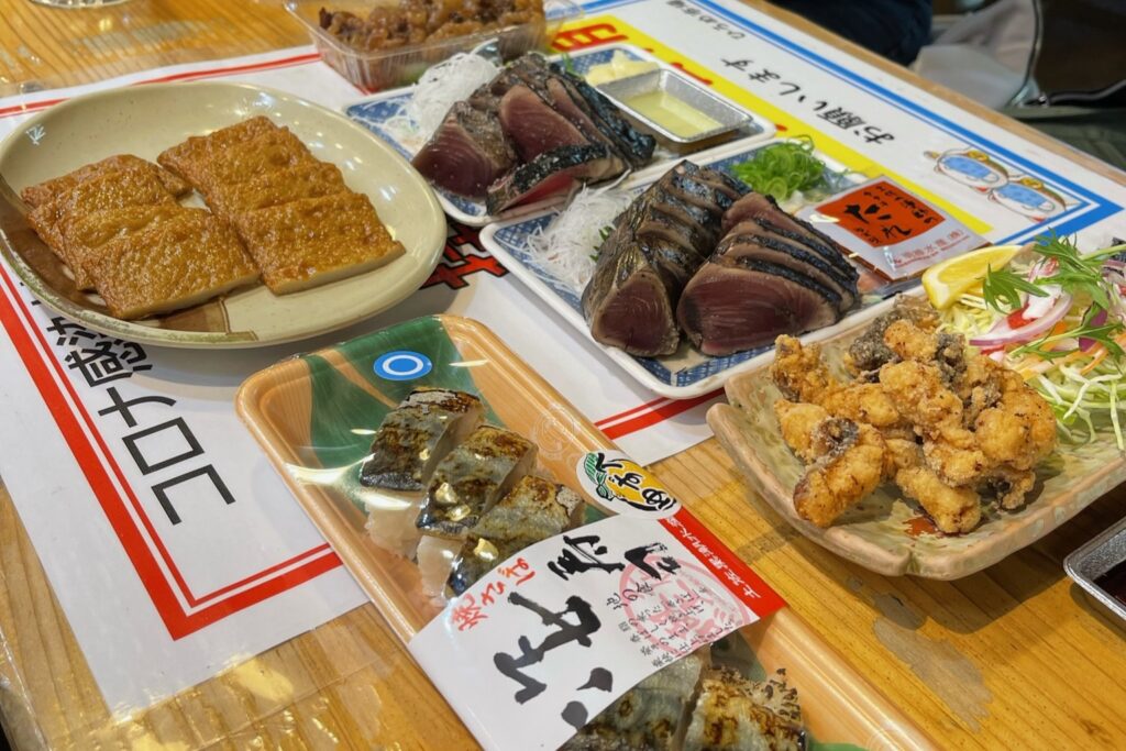 A variety of local Kochi dishes, including Katsuo no Tataki (seared bonito) and grilled mackerel sushi.