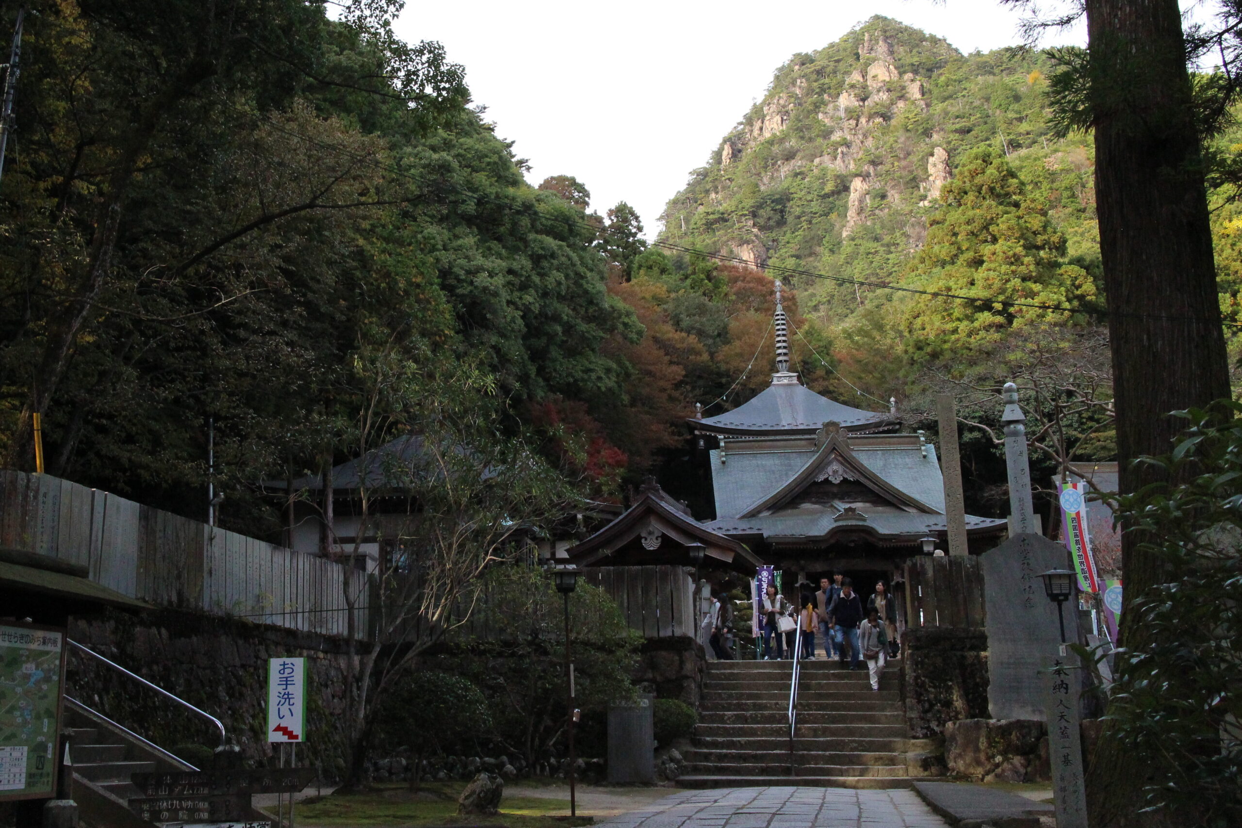 Pilgrims emerge from the main hall of Ōkubo-ji temple beneath Mt. Nyotai.