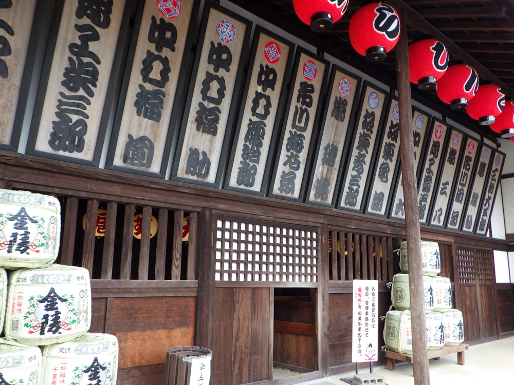 The traditional wooden entrance decorated with sake barrels and 'Maneki' banners bearing the names of famous Kabuki actors.