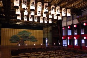 The authentic Edo-period stage featuring a classic pine tree backdrop under a ceiling of elegant paper lanterns.