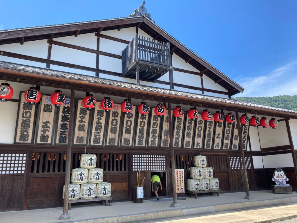 Exterior of the historic Kanamaruza kabuki theater building in Kotohira, Kagawa, with rows of red lanterns and actor name boards