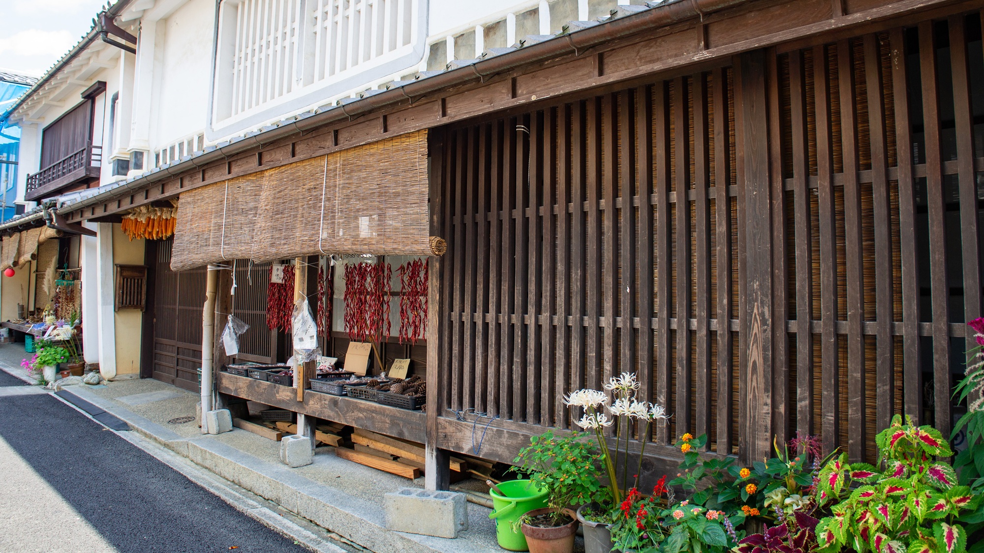 Dried chili peppers and baskets of local produce line a shopfront in Uchiko's historic district, where family-run stores sell handmade goods, crafts, and souvenirs.
