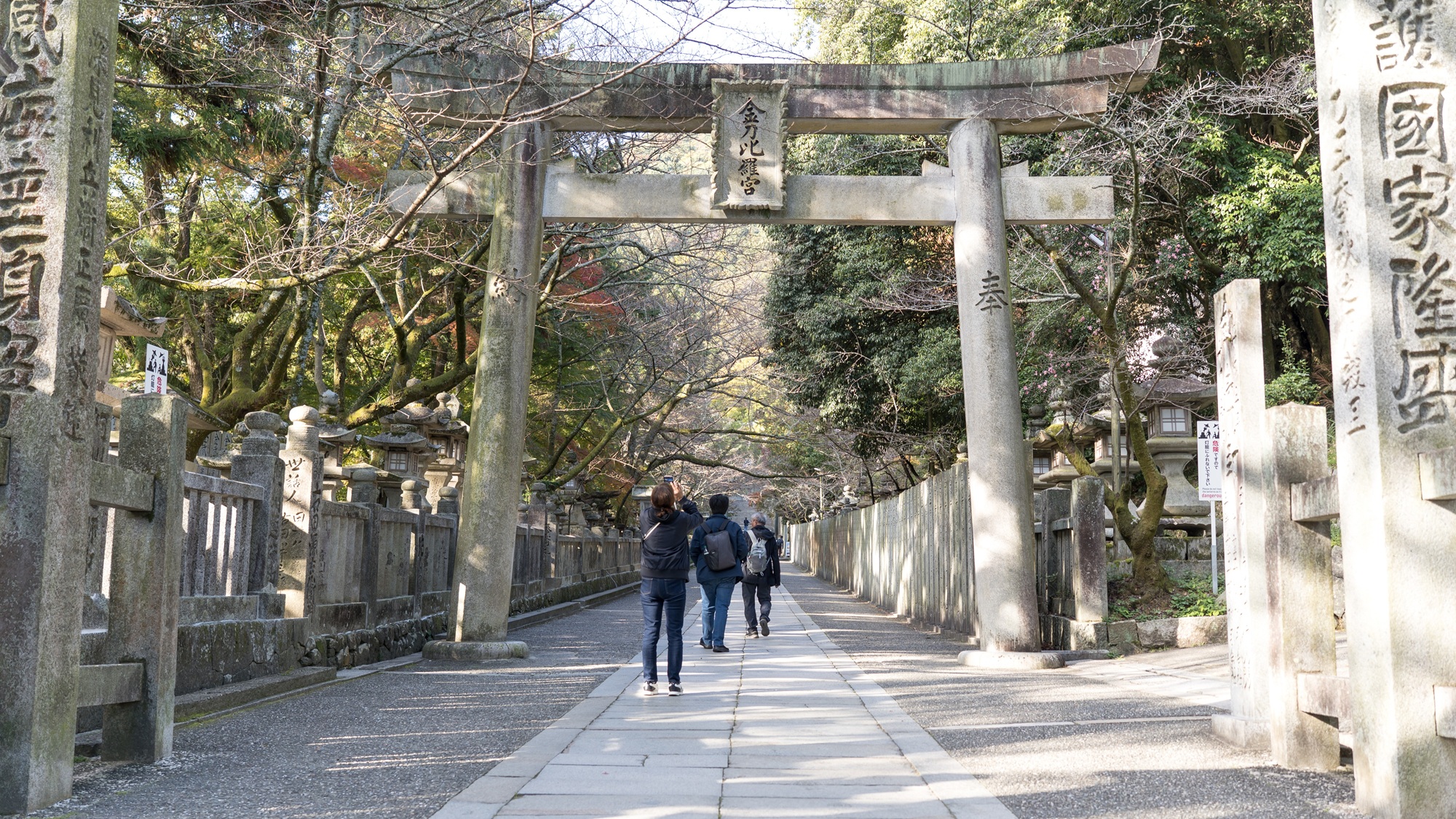 The great stone torii marks where the everyday ends: past this gate the path belongs to Ōmononushi, god of the sea and seafarers.