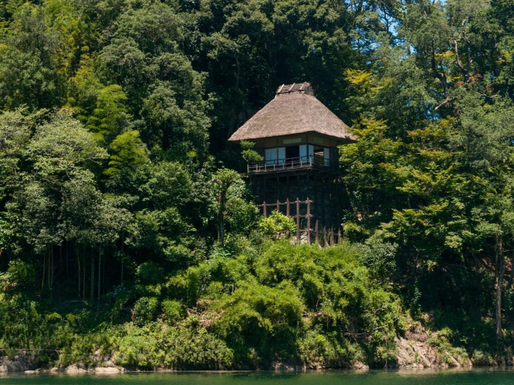 Furo-an projecting over the cliff on wooden kakezukuri pillars, seen from the Hijikawa River