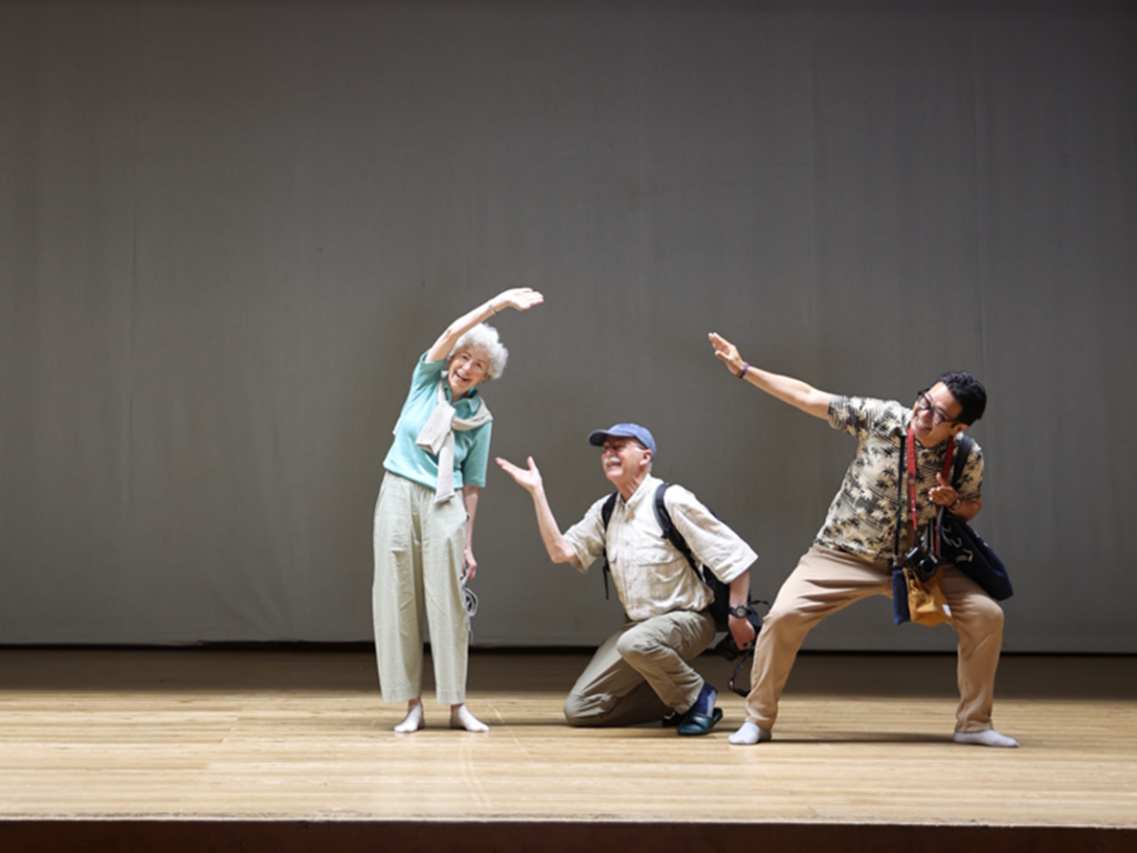 Guests and guide posing on the wooden stage of Yusuhara-za, a historic theater in Yusuhara Town, Kochi"