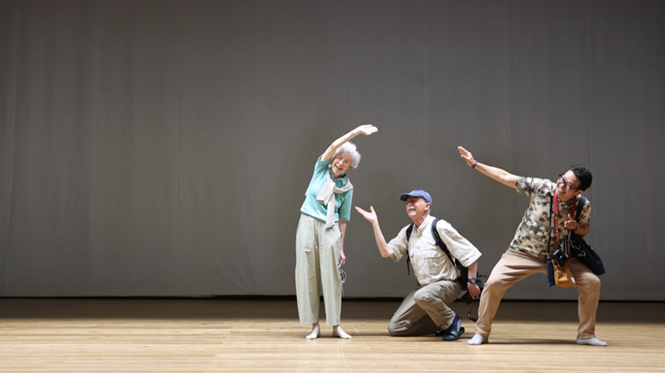 Guests and guide posing on the wooden stage of Yusuhara-za, a historic theater in Yusuhara Town, Kochi"