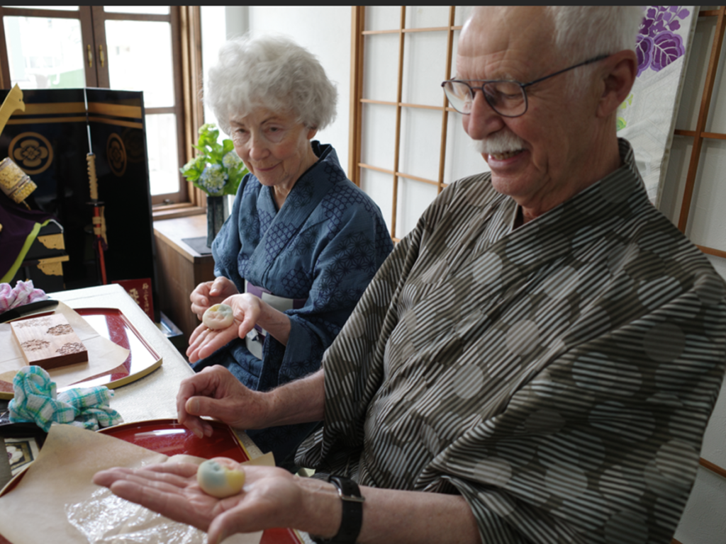 Couple in yukata shaping traditional Japanese wagashi sweets during a hands-on workshop