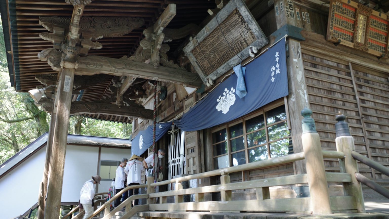 White-clad pilgrims prayer at the main hall of Gokuraku-ji, a wooden building that dates to the 17th century.