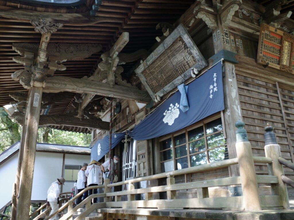 White-clad pilgrims prayer at the main hall of Gokuraku-ji, a wooden building that dates to the 17th century.