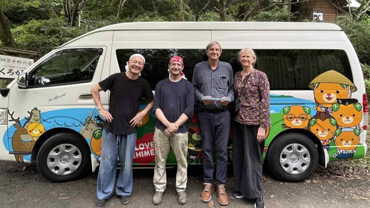 Margaret and her husband with the blacksmiths of Kobo Kurogane in front of a van decorated with Ehime's mascot, Nishitosa, Kochi