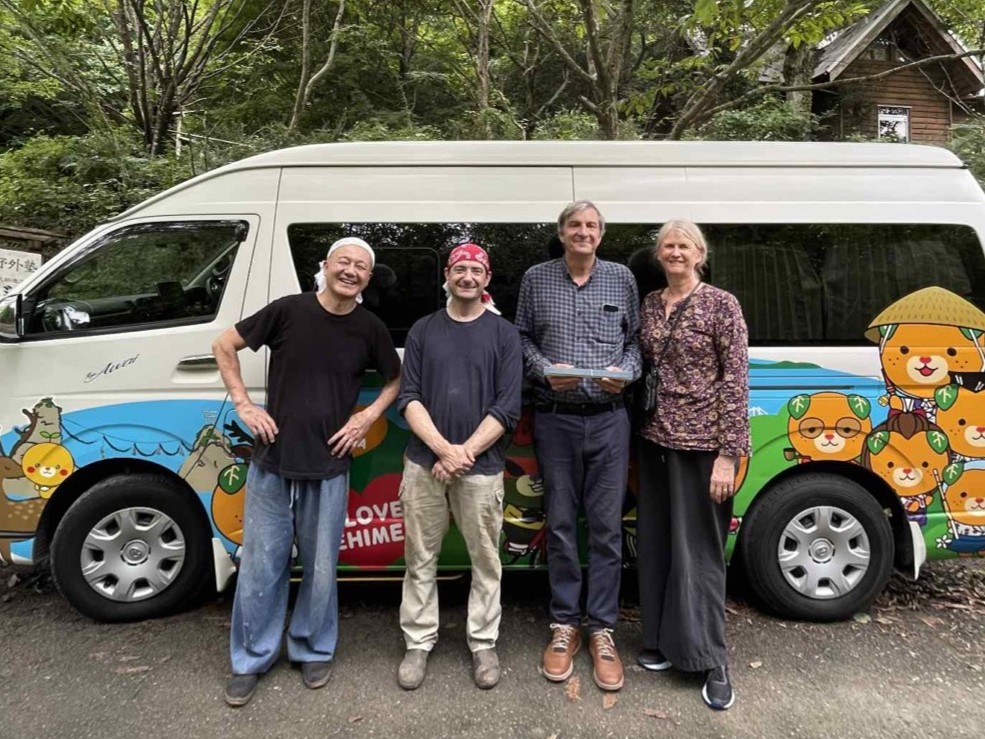 Margaret and her husband with the blacksmiths of Kobo Kurogane in front of a van decorated with Ehime's mascot, Nishitosa, Kochi