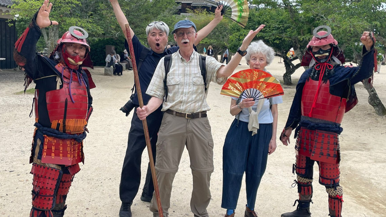 Guests posing with samurai armor performers on the grounds of Matsuyama Castle, Ehime
