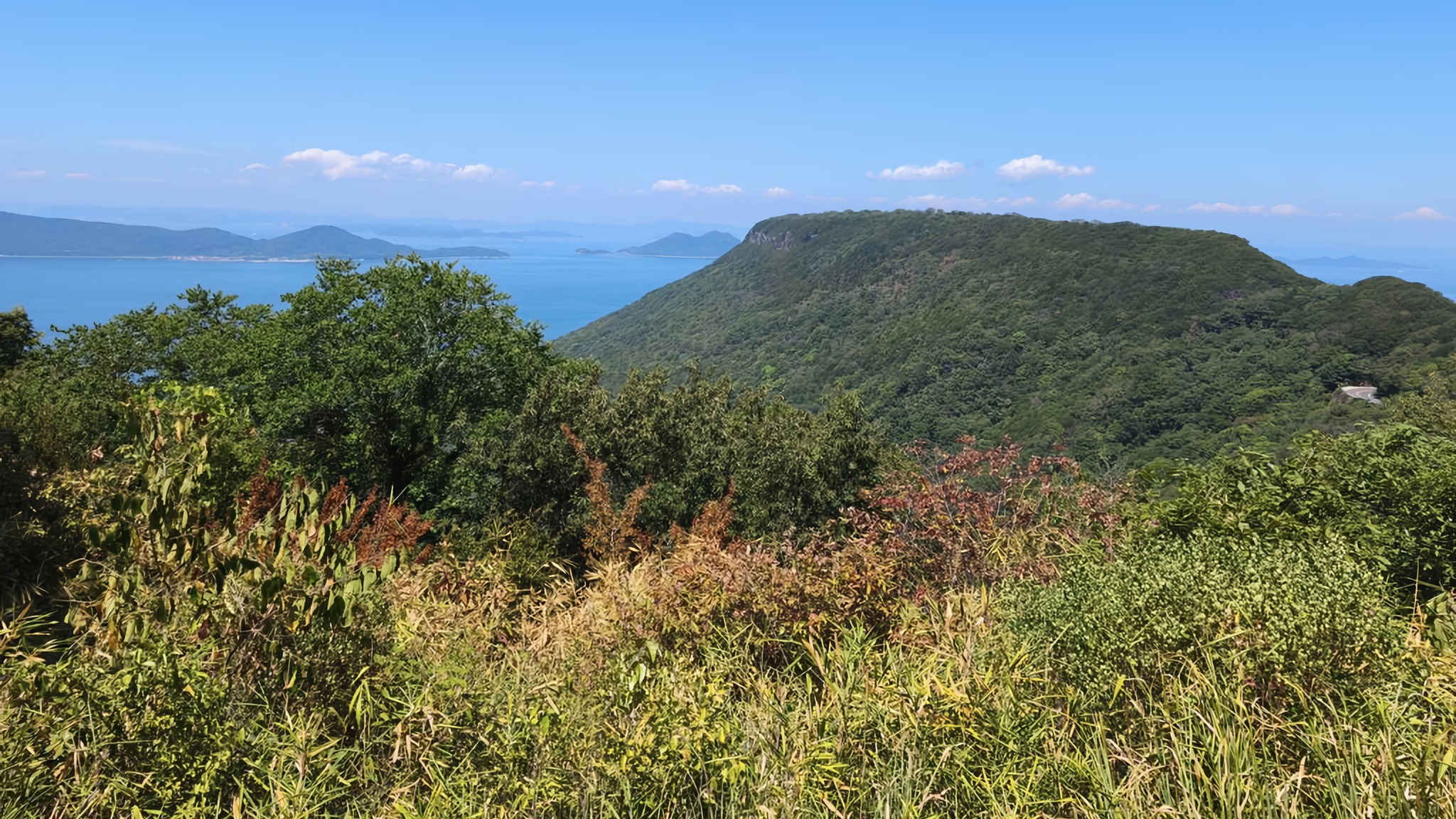 The green slopes of Yashima's northern peak stand stark against sapphire blue seas and skies.