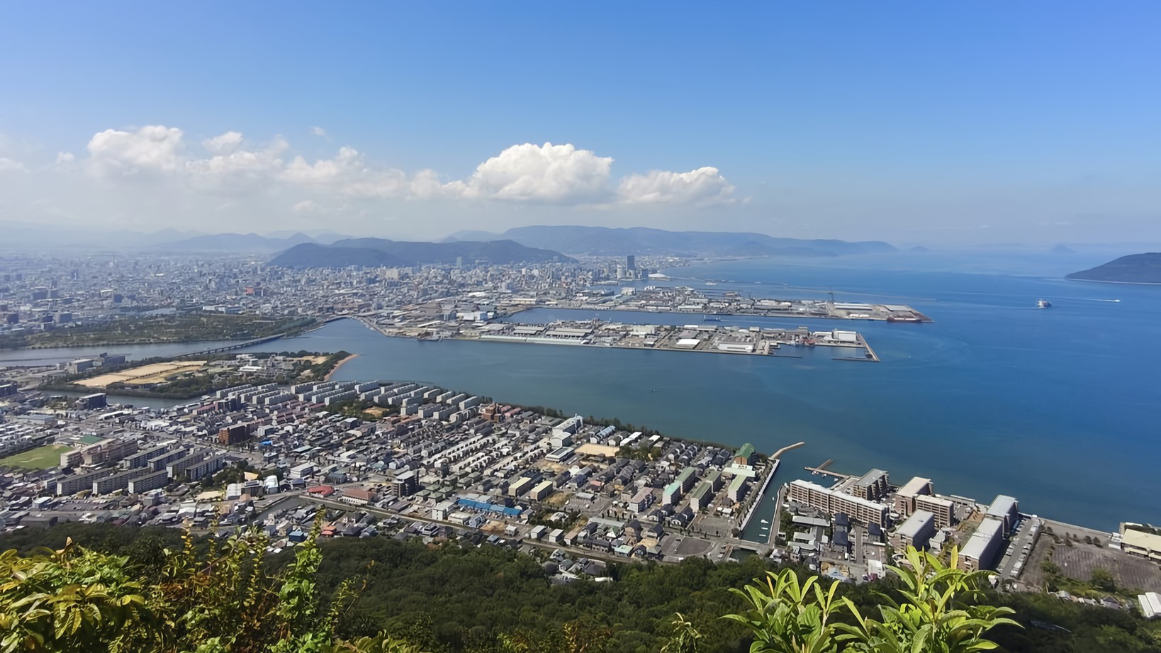 A sweeping panorama of the placid Seto Inland Sea and downtown Takamatsu City, as seen from the Shishi no Reigan Viewpoint on Yashima.