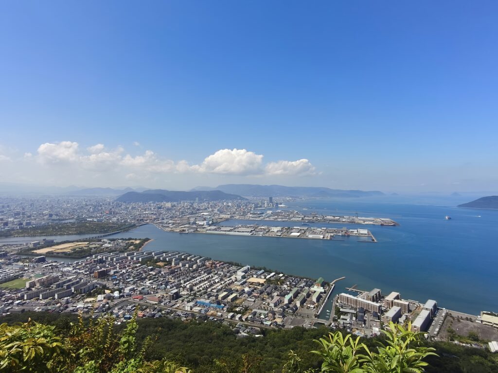 A sweeping panorama of the placid Seto Inland Sea and downtown Takamatsu City, as seen from the Shishi no Reigan Viewpoint on Yashima.