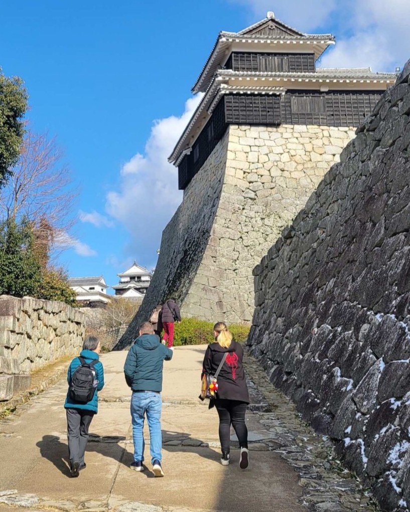 The sweeping stone walls of Matsuyama castle, made veen harder to climb by overhanging structures for dropping stones on attackers. 