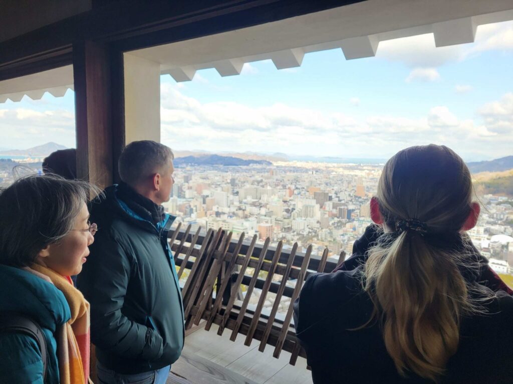 Visitors look down from the top of the Tenshū tower. The fortress has watched Matsuyama transform from a medieval castle town to a vibrant, modern city.